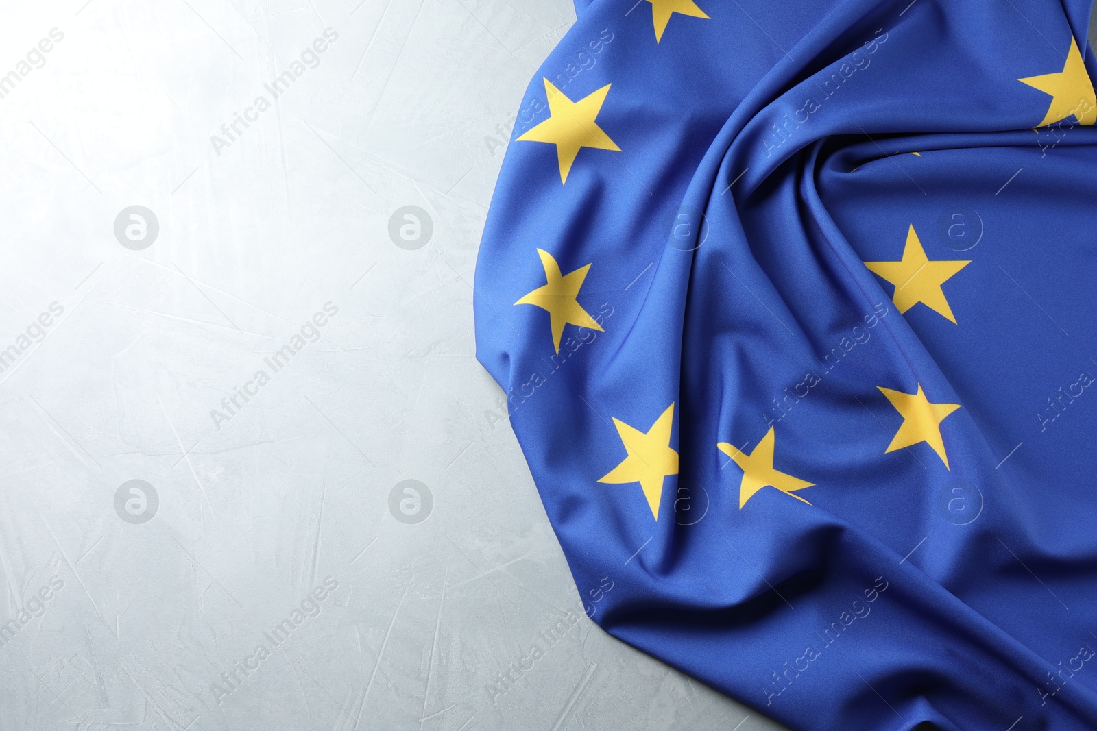 Photo of Flag of European Union on light grey table, space for text