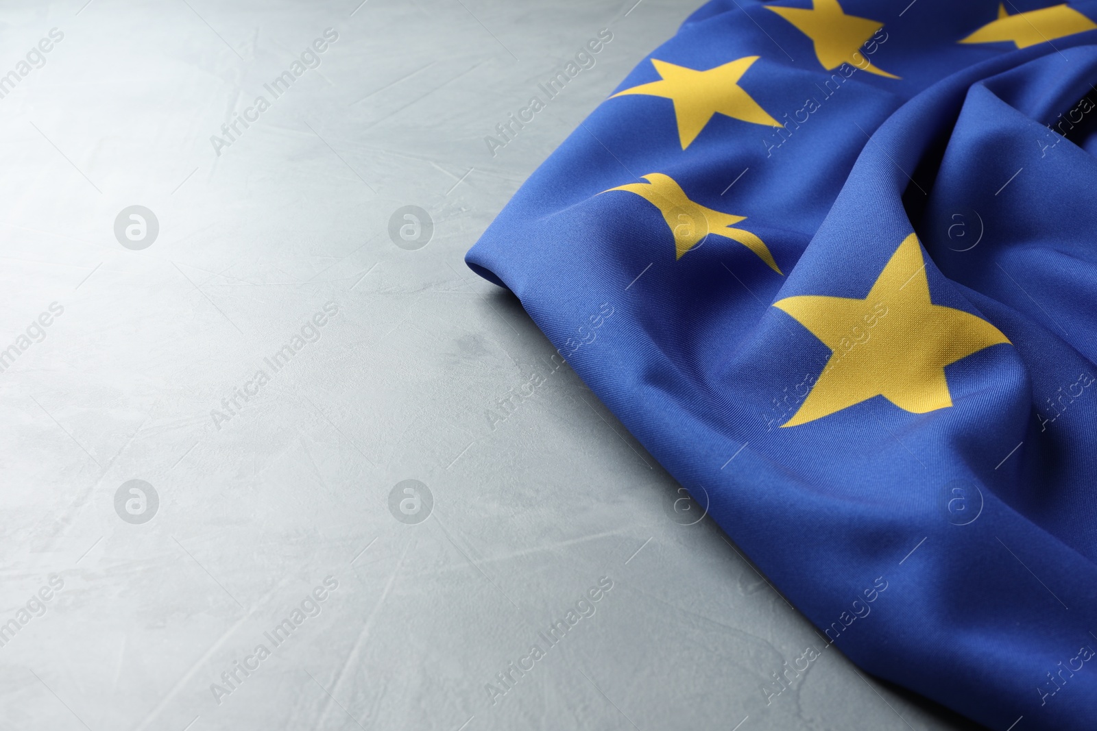 Photo of Flag of European Union on light grey table, space for text