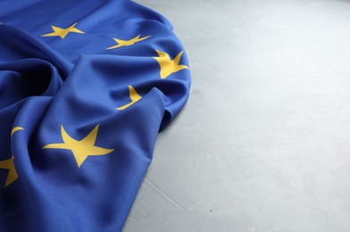 Photo of Flag of European Union on light grey table, space for text