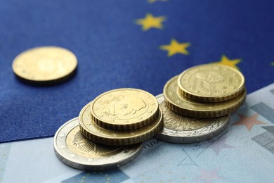 Photo of Coins and euro banknote on European Union flag, closeup