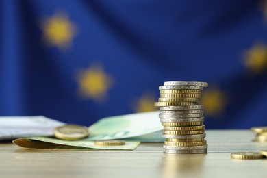 Photo of Coins and euro banknotes on wooden table, closeup