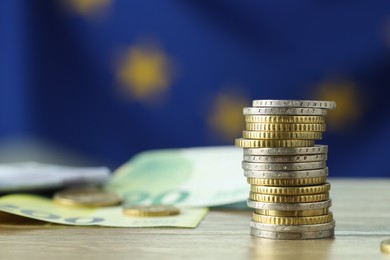 Photo of Coins and euro banknotes on wooden table, closeup