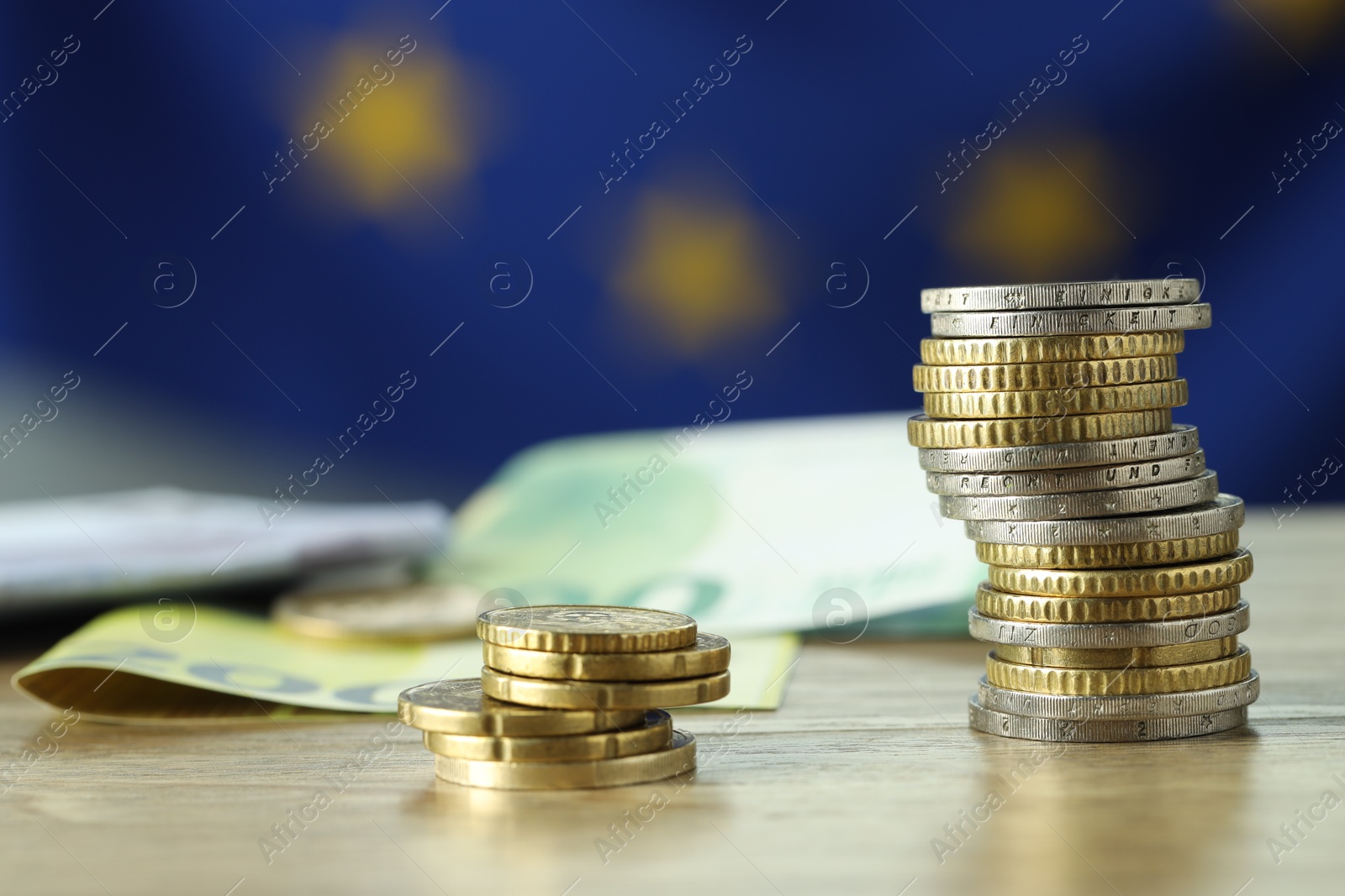 Photo of Coins and euro banknotes on wooden table, closeup