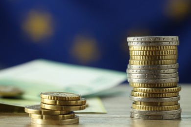 Photo of Different euro coins on wooden table, closeup