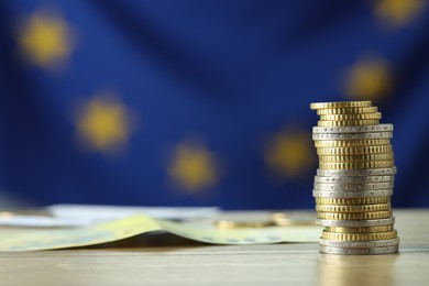 Photo of Stack of euro coins on wooden table, closeup