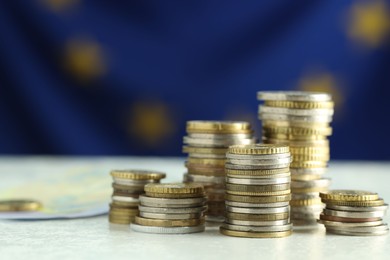 Stacks of euro coins on white table, closeup