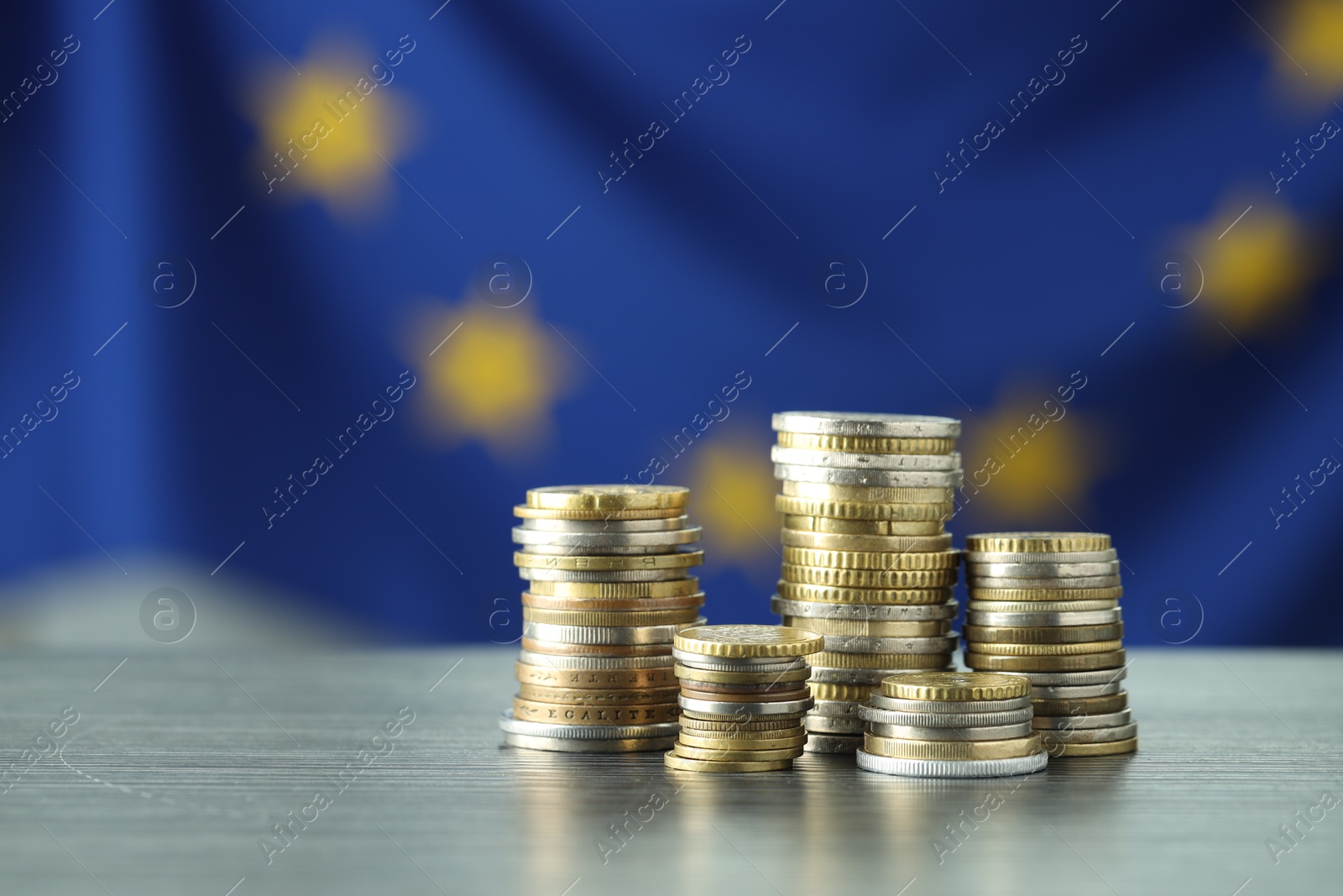 Photo of Stacks of euro coins on grey textured table