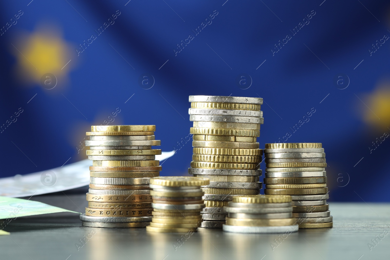 Photo of Stacks of coins on grey table, closeup