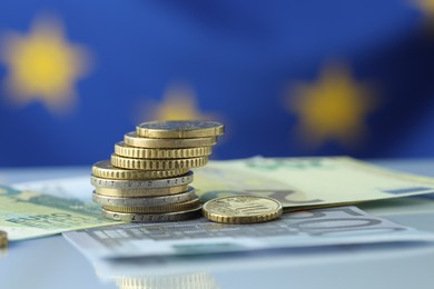 Photo of Coins and euro banknotes on table, closeup