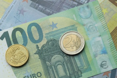 Photo of Different coins on euro banknotes, top view