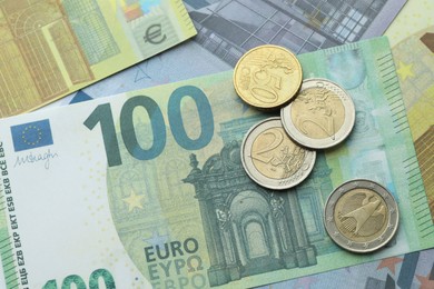 Photo of Different coins on euro banknotes, top view