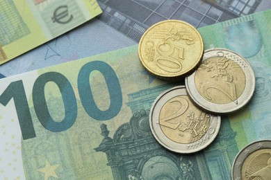 Photo of Different coins on euro banknotes, top view