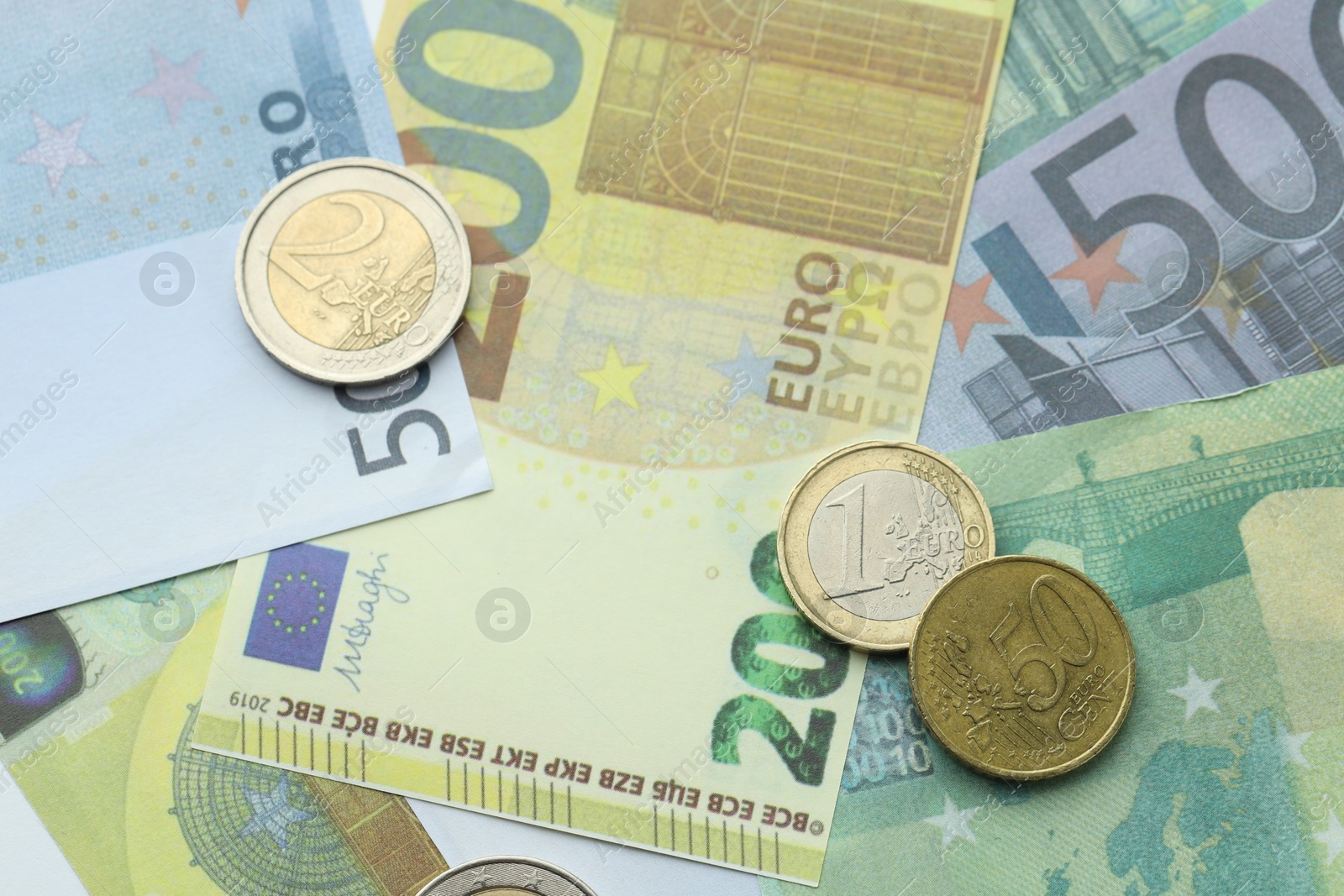 Photo of Different coins on euro banknotes, top view