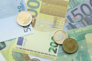 Photo of Different coins on euro banknotes, top view