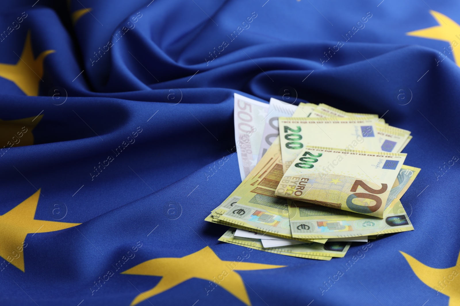 Photo of Euro banknotes on European Union flag, closeup