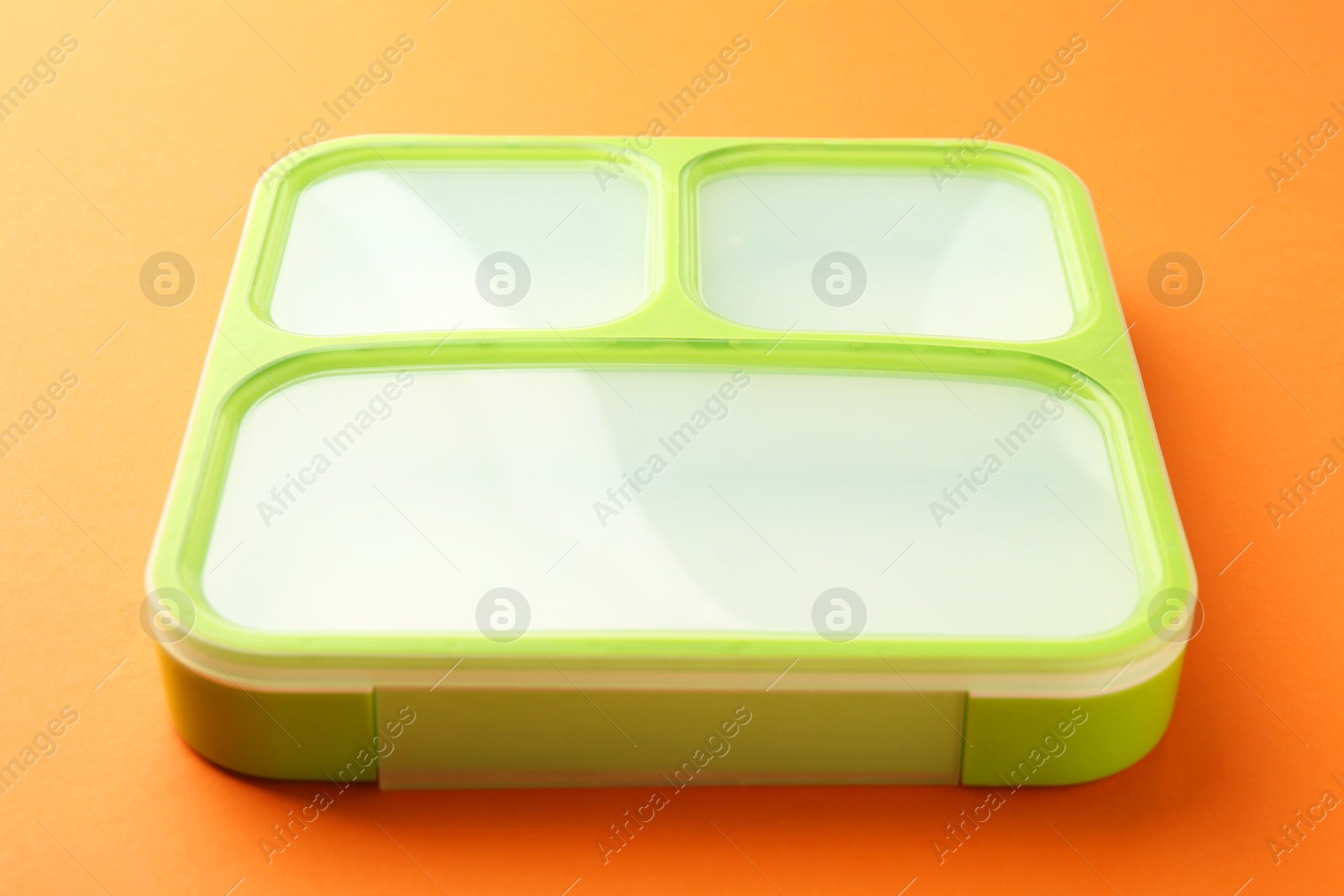 Photo of One bright lunch box on orange background