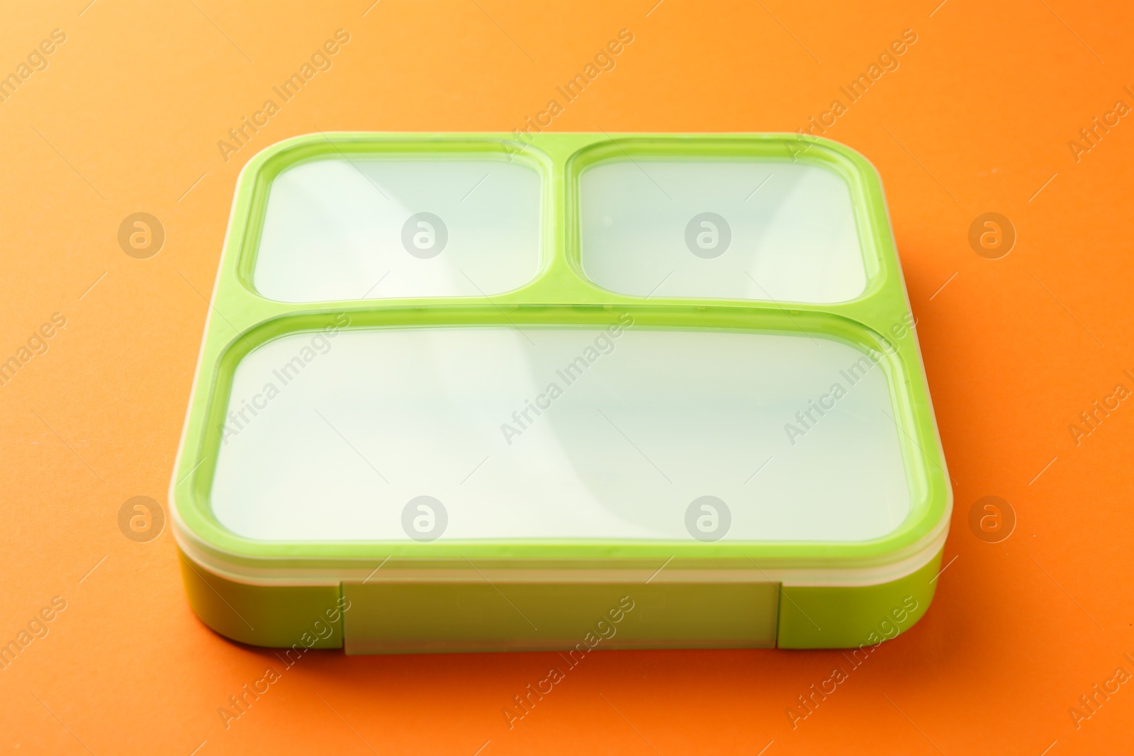 Photo of One bright lunch box on orange background