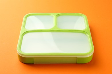 Photo of One bright lunch box on orange background