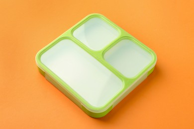 Photo of One lunch box on orange background, above view