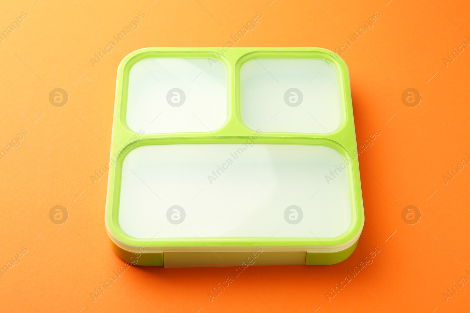 Photo of One lunch box on orange background, above view