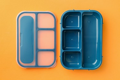 Photo of One empty lunch box on orange background, flat lay