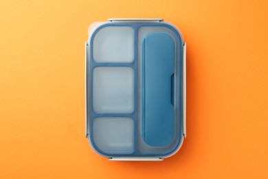 One lunch box on orange background, top view