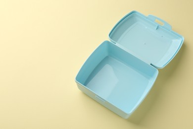 Photo of One empty lunch box on beige background, above view. Space for text