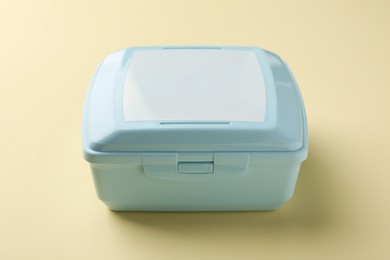 Photo of One light blue lunch box on beige background