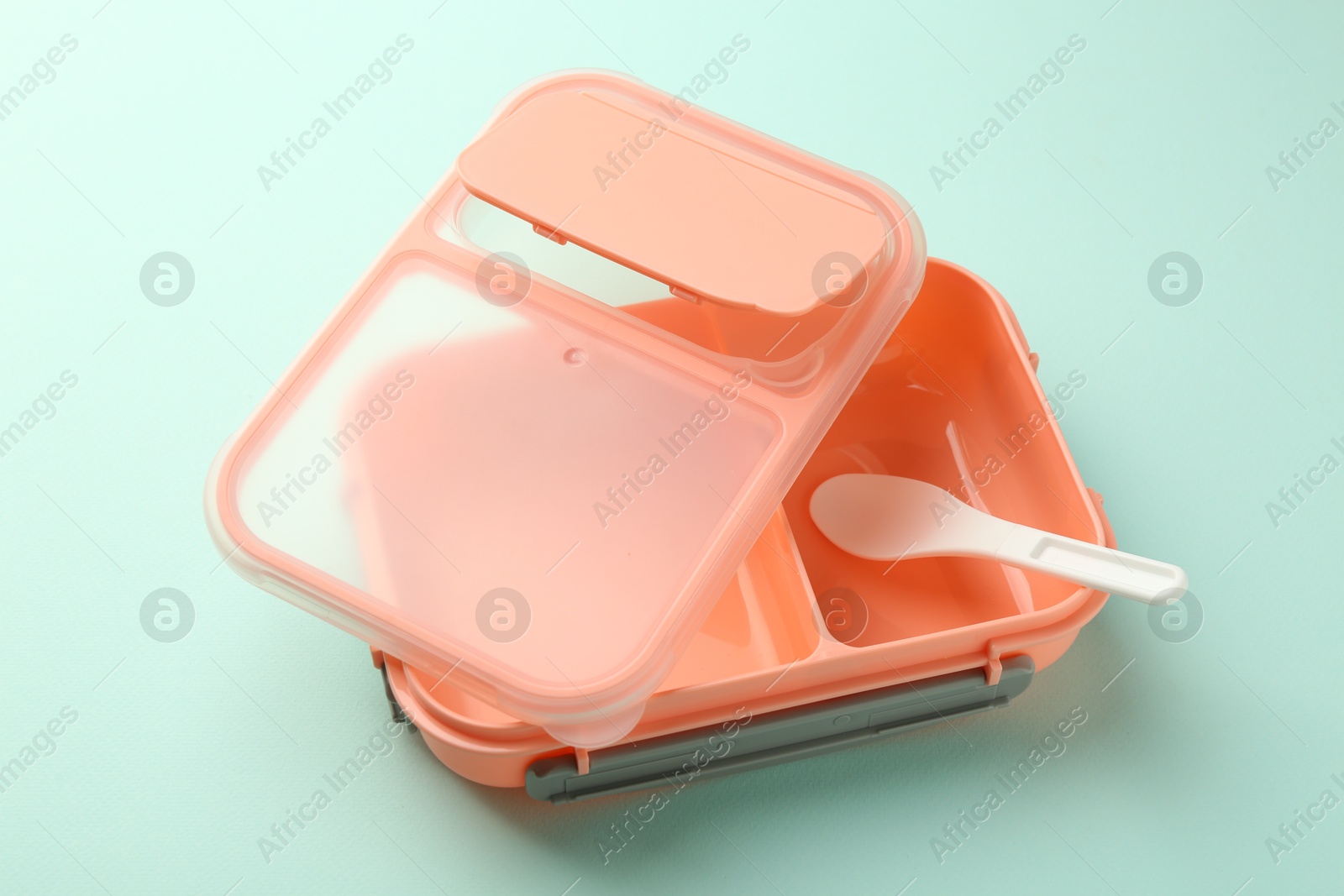 Photo of Empty lunch box with spoon on light blue background