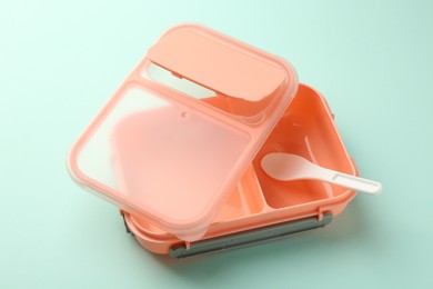 Photo of Empty lunch box with spoon on light blue background