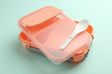 Photo of Empty lunch box with spoon on light blue background