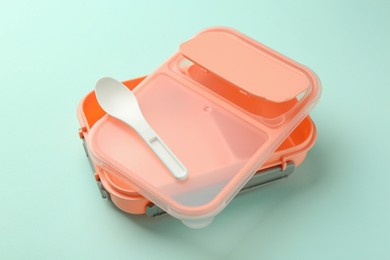 Photo of Empty lunch box with spoon on light blue background