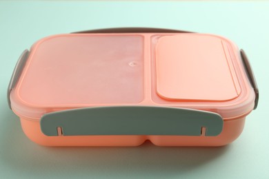 Photo of One empty lunch box on light blue background, closeup