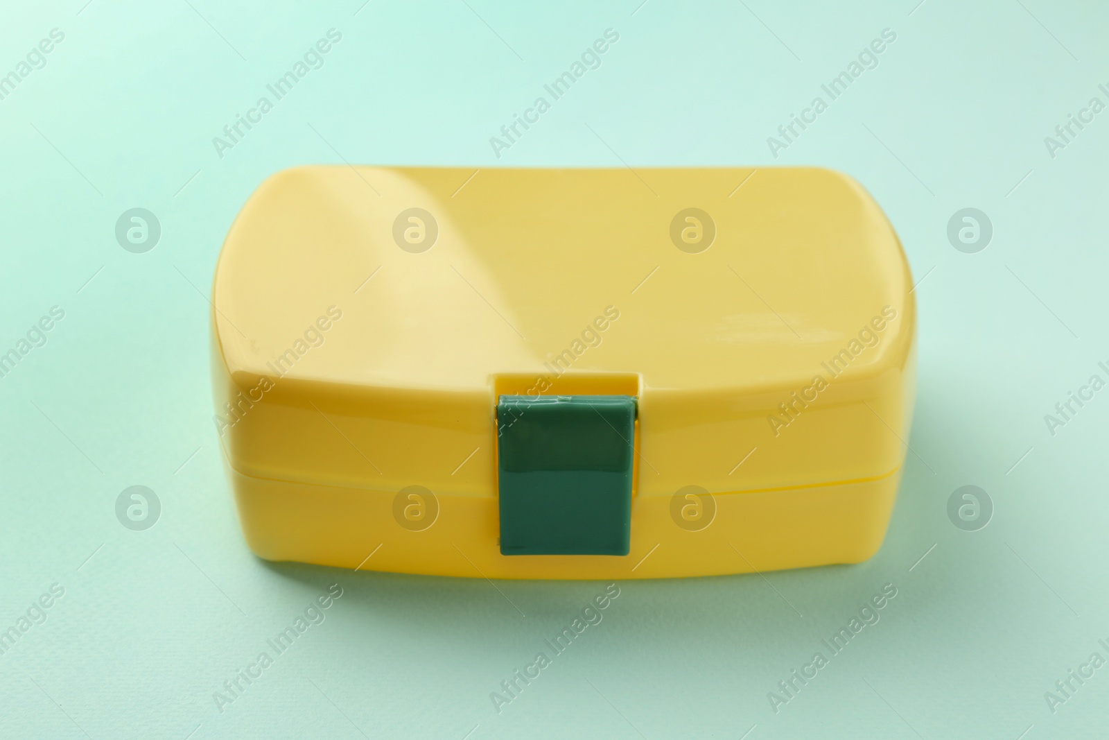 Photo of One yellow lunch box on light blue background