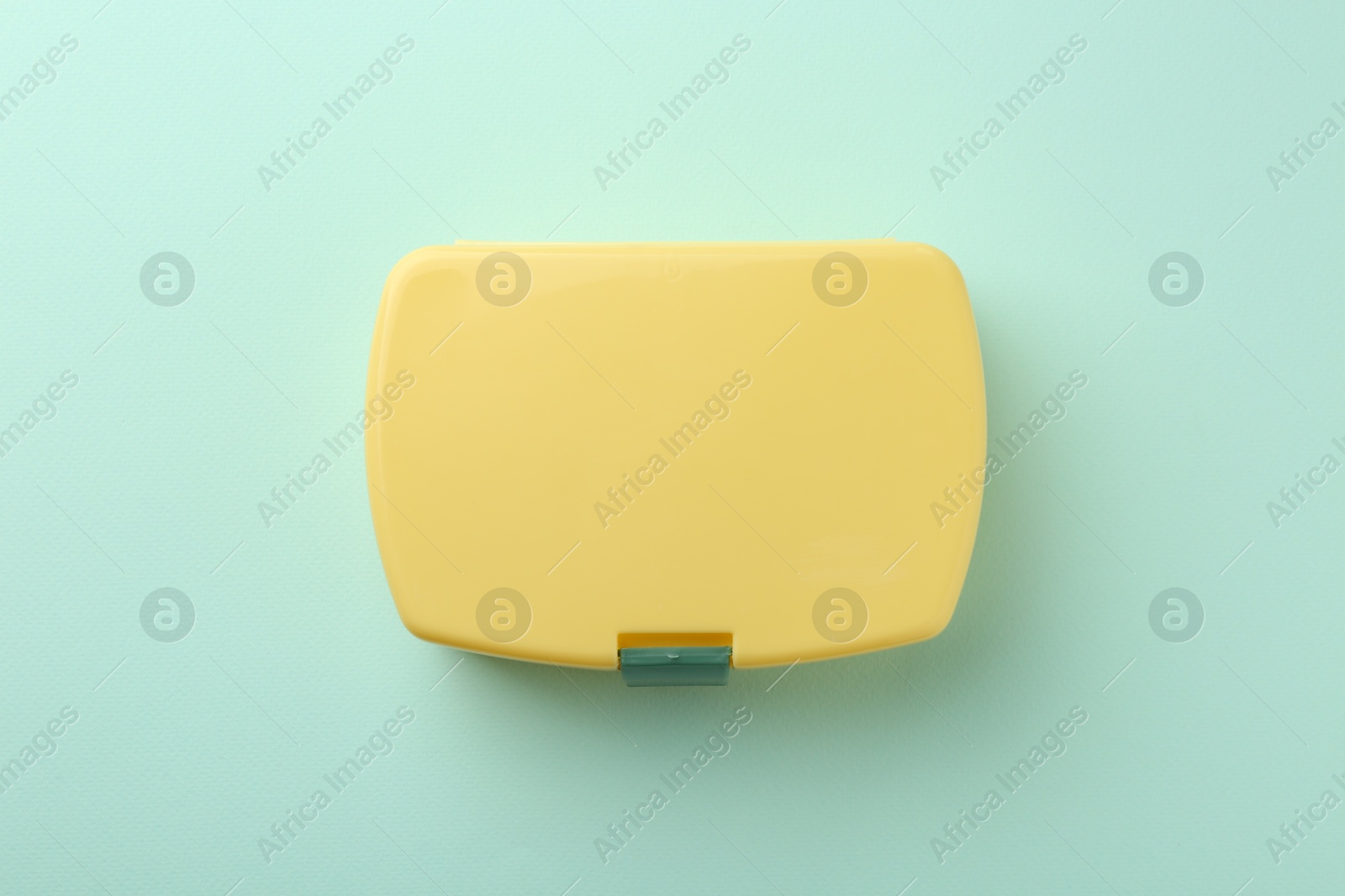 Photo of One yellow lunch box on light blue background, top view