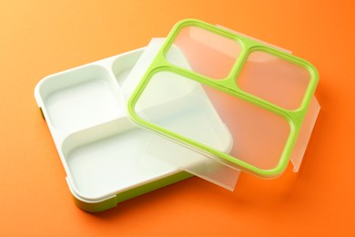 Photo of One empty lunch box on orange background