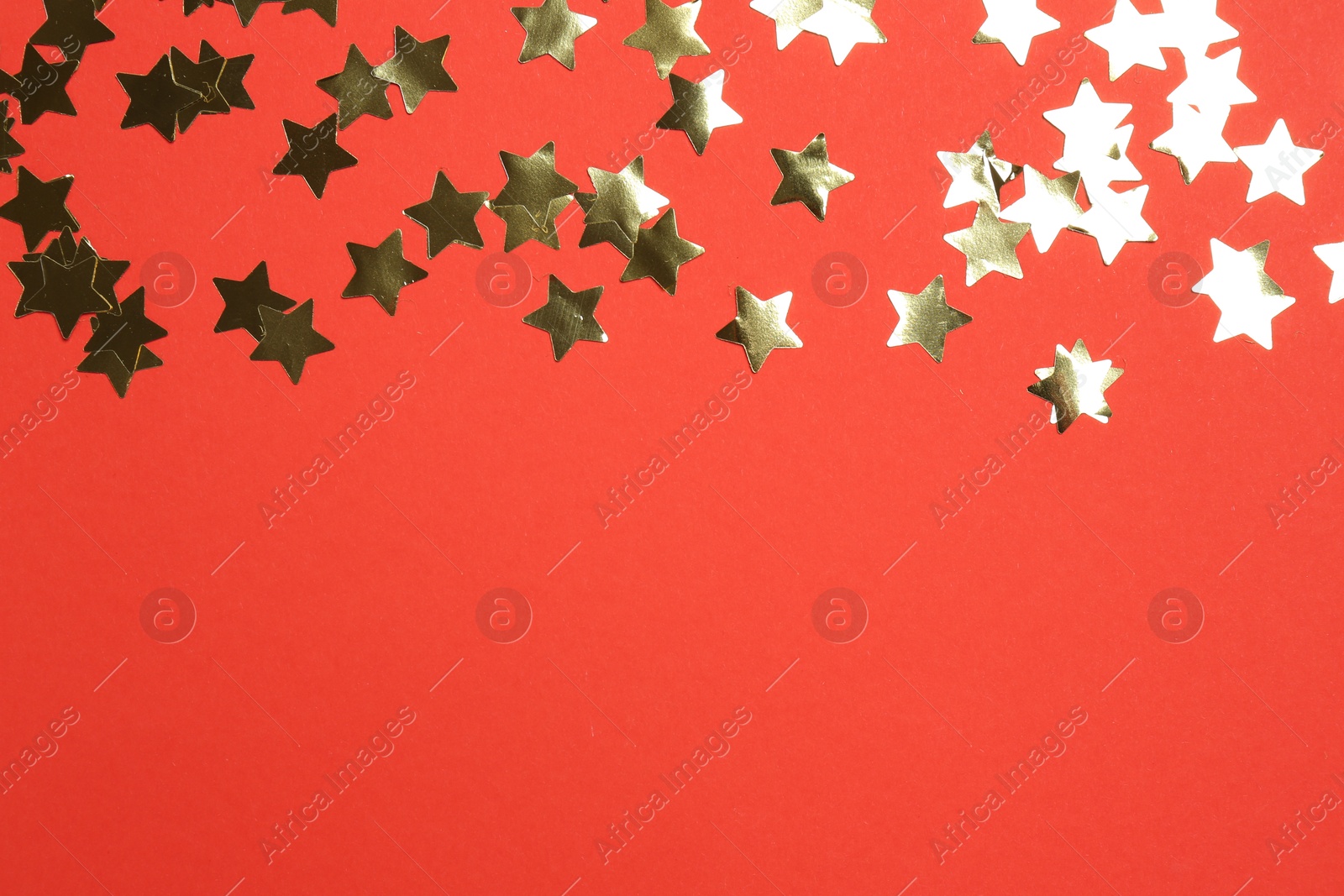 Photo of Shiny confetti on red background, flat lay. Space for text