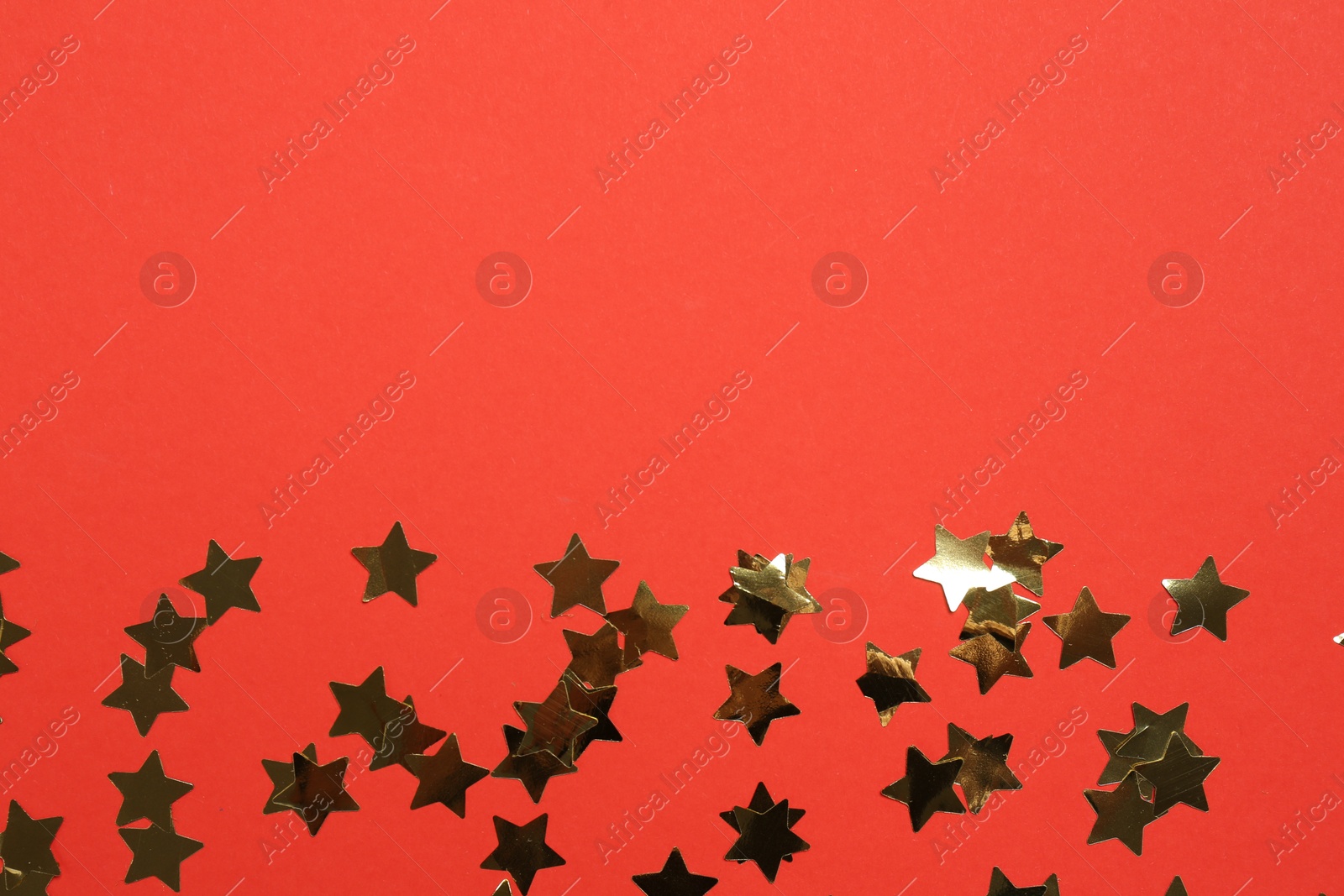 Photo of Shiny confetti on red background, flat lay. Space for text