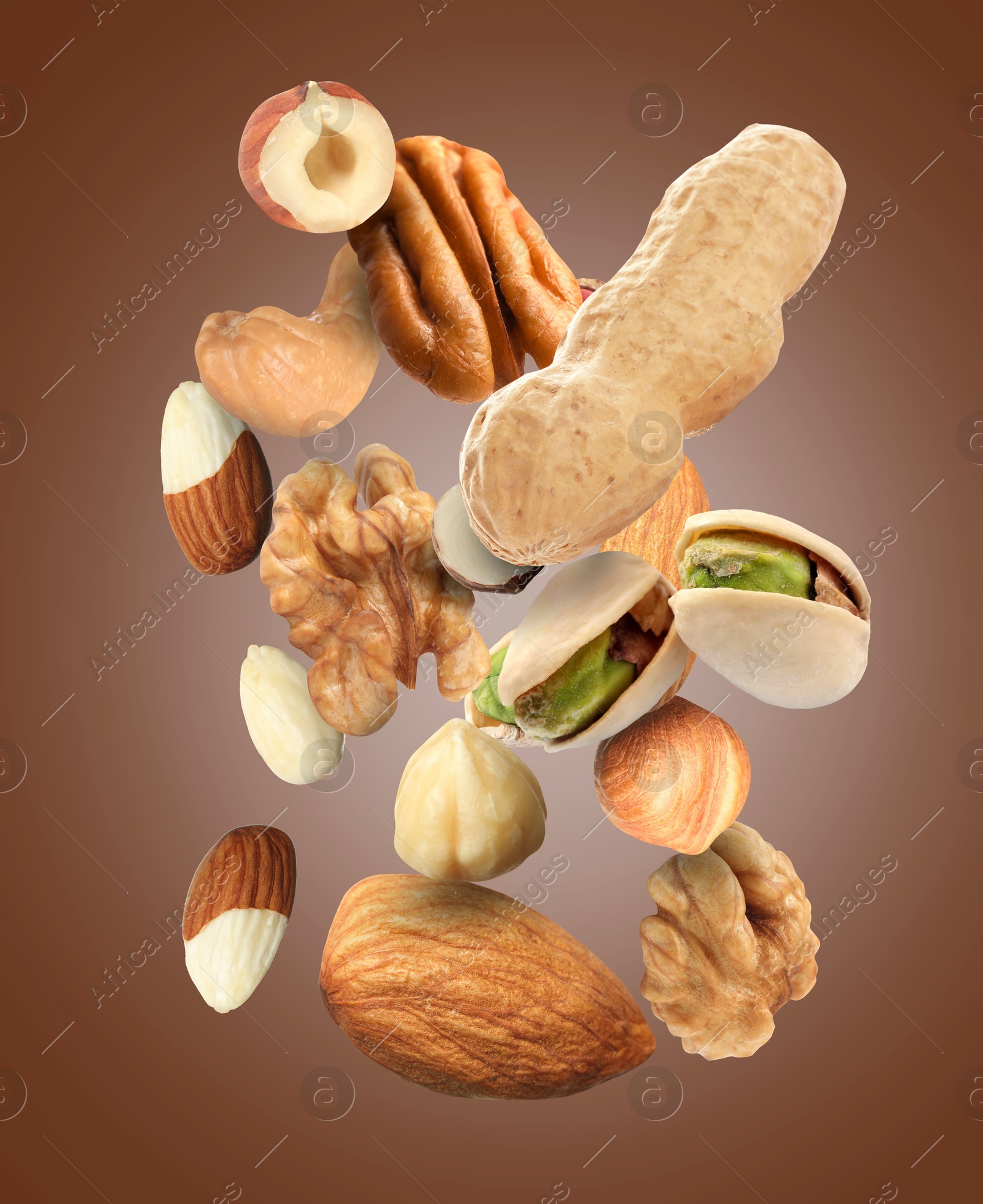 Image of Pecan and other nuts in air on brown background