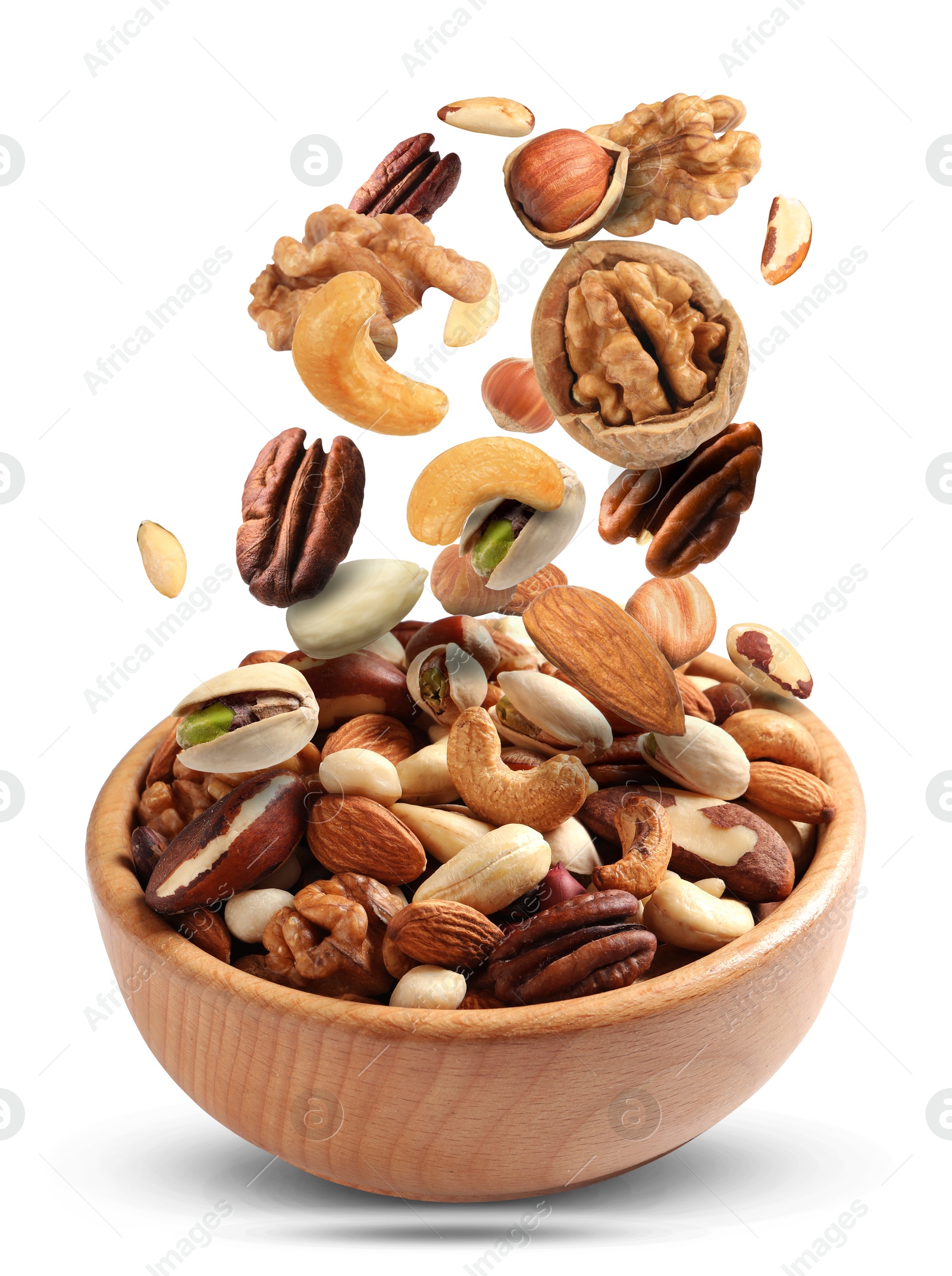 Image of Pecan and other nuts falling into wooden bowl on white background