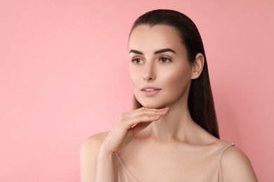 Attractive woman with perfect skin on pink background