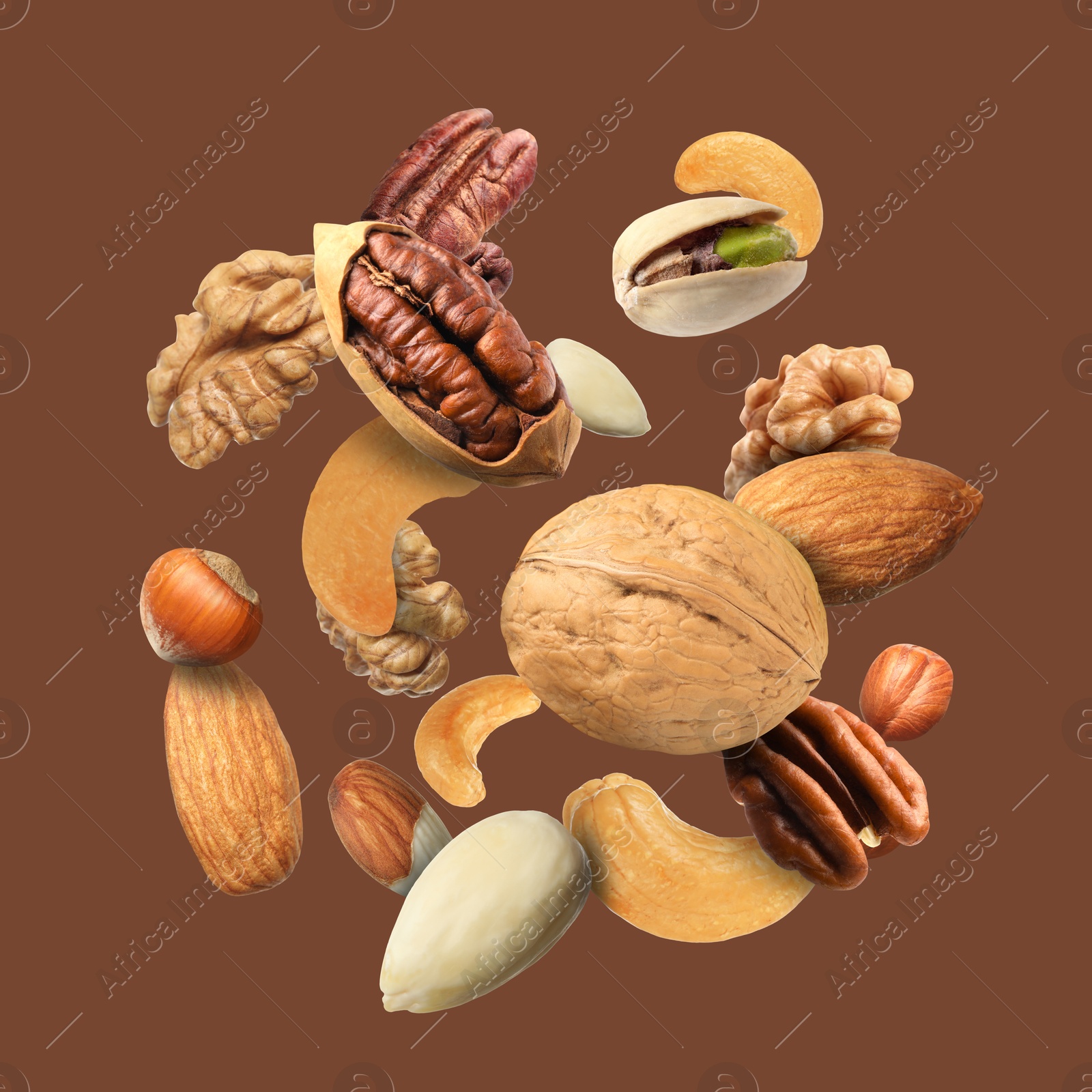 Image of Pecan and other nuts in air on brown background