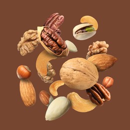 Image of Pecan and other nuts in air on brown background