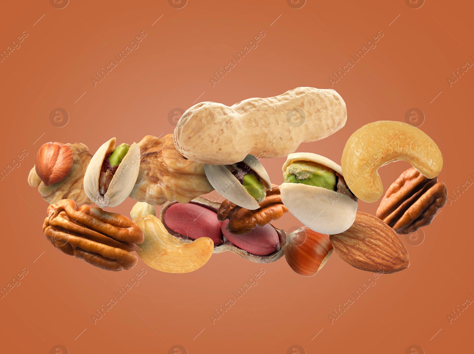 Image of Pecan and other nuts in air on brown background