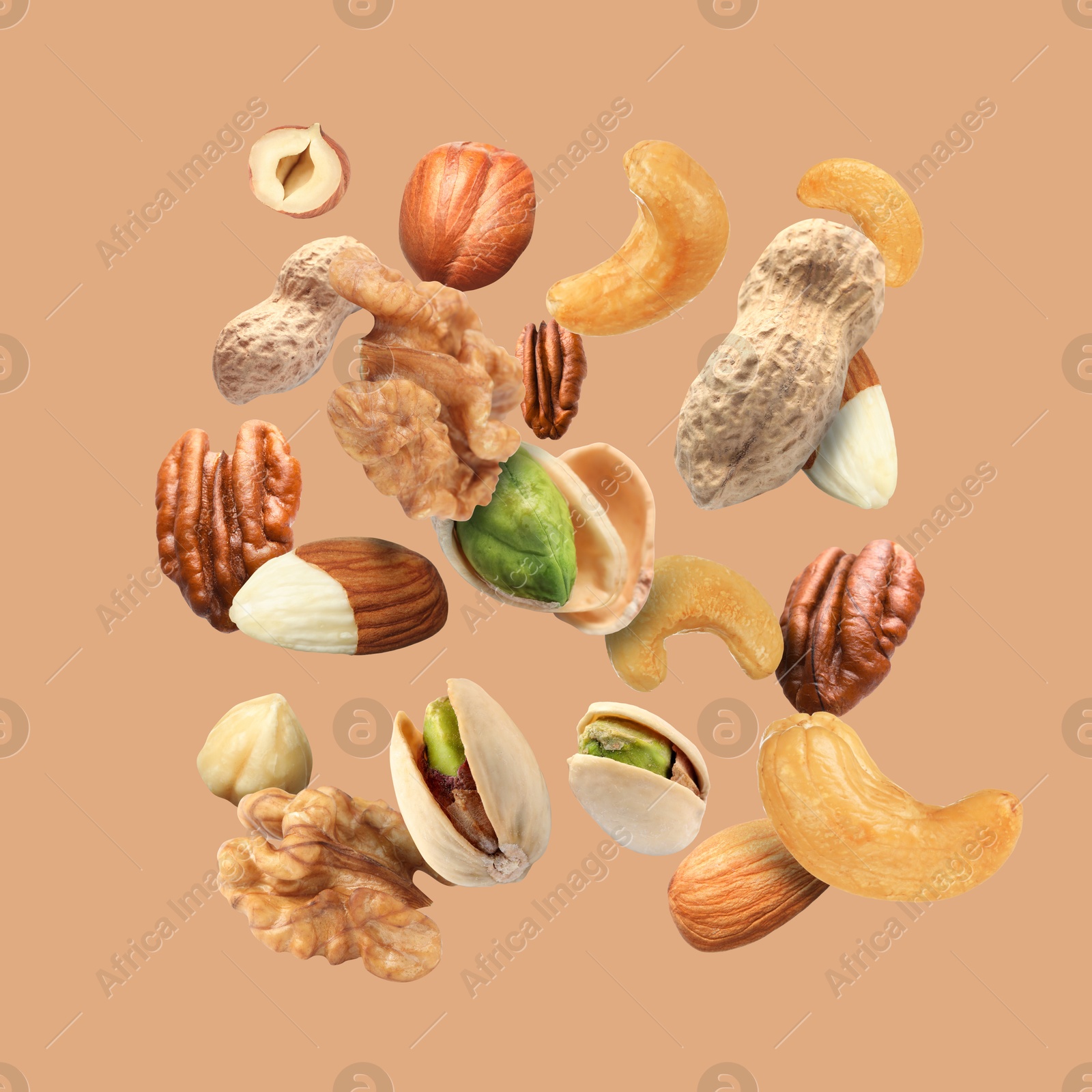 Image of Pecan and other nuts in air on dark beige background