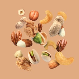 Image of Pecan and other nuts in air on dark beige background