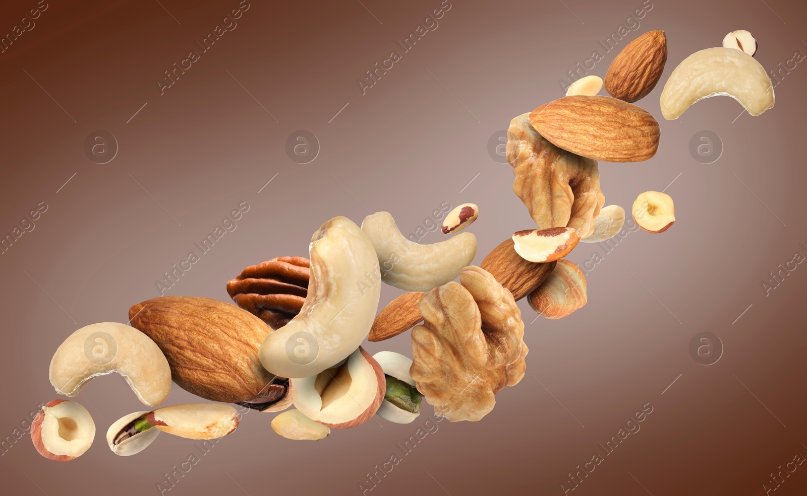 Image of Pecan and other nuts in air on brown background