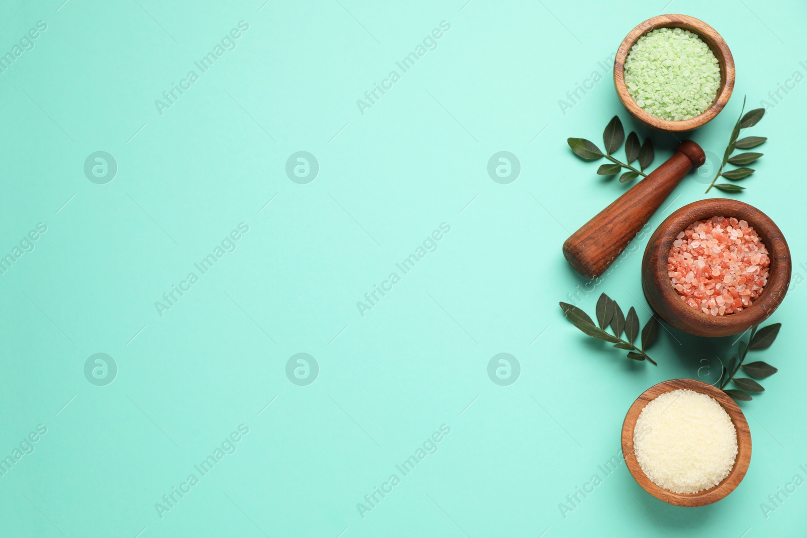 Photo of Different cosmetic products and green leaves on turquoise background, flat lay. Space for text