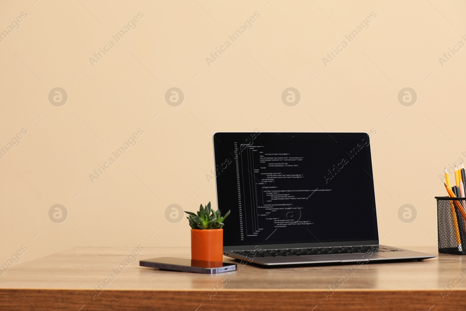 Photo of Programmer's workplace. Modern laptop with unfinished code on desk