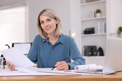 Photo of Architect making engineering drawing at table in office